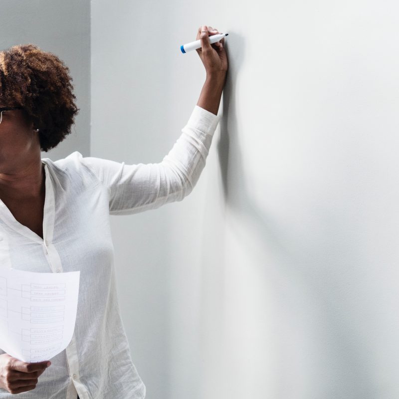Woman writing on whiteboard