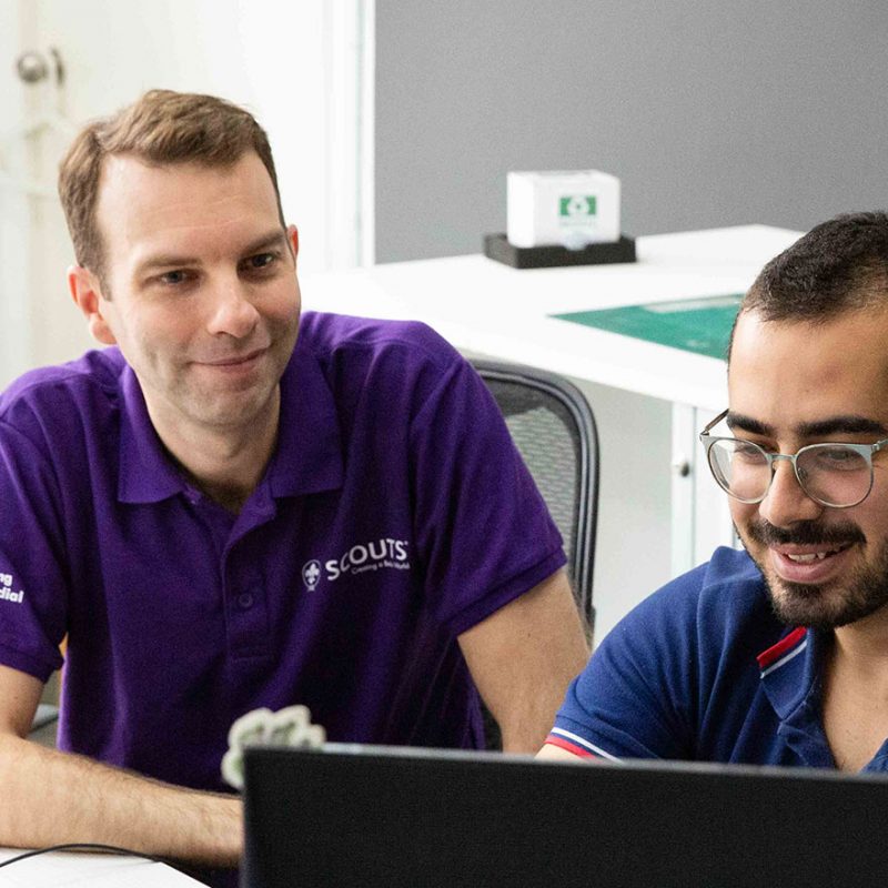 David sat with colleague working