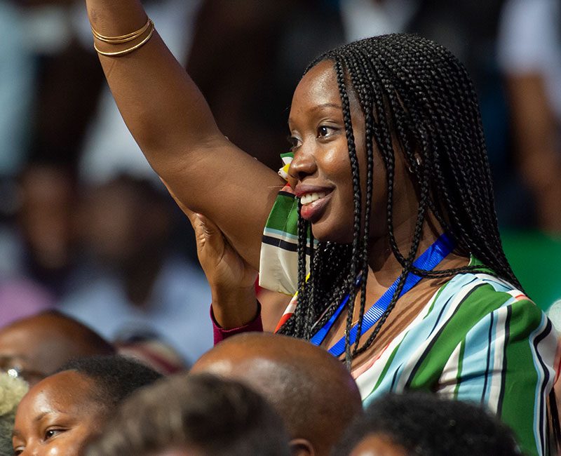 Young woman with hand in the air at conference