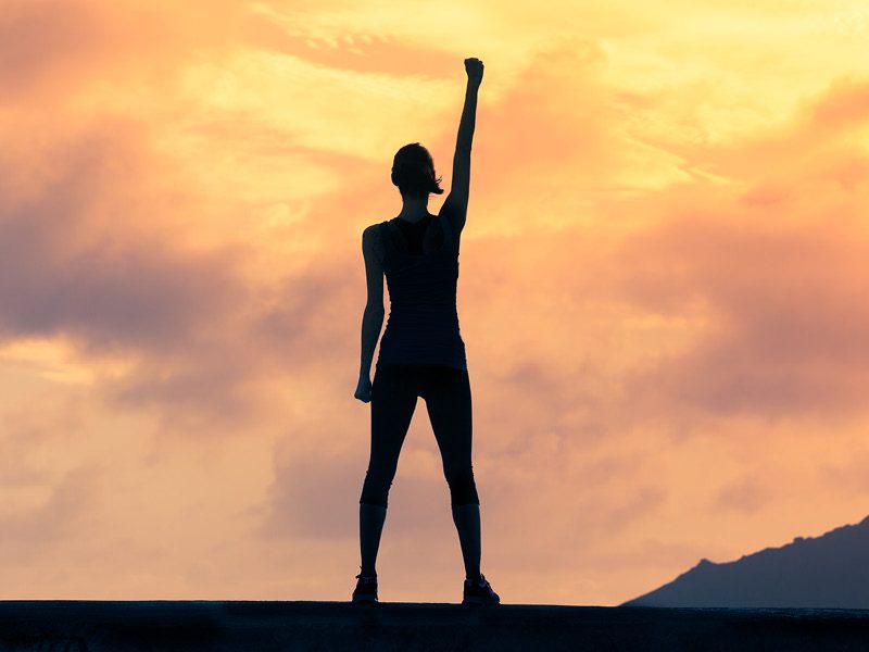 Young woman with arm raised triumphantly