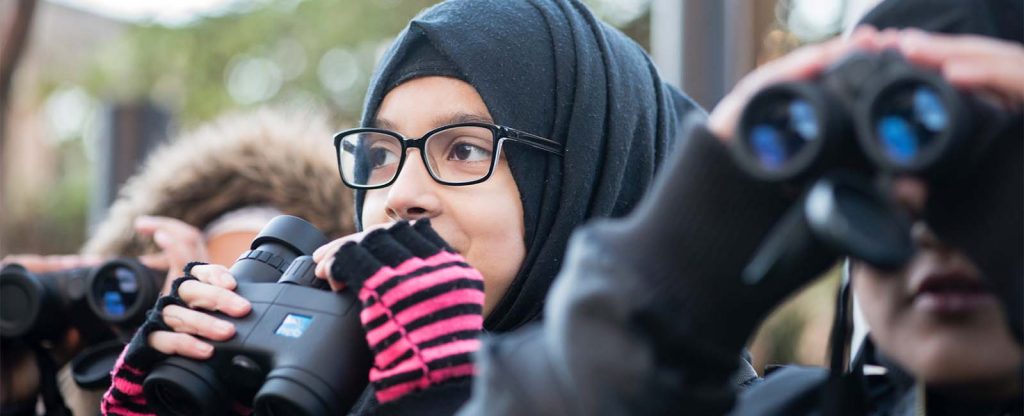 Young girls holding RSPB binoculars
