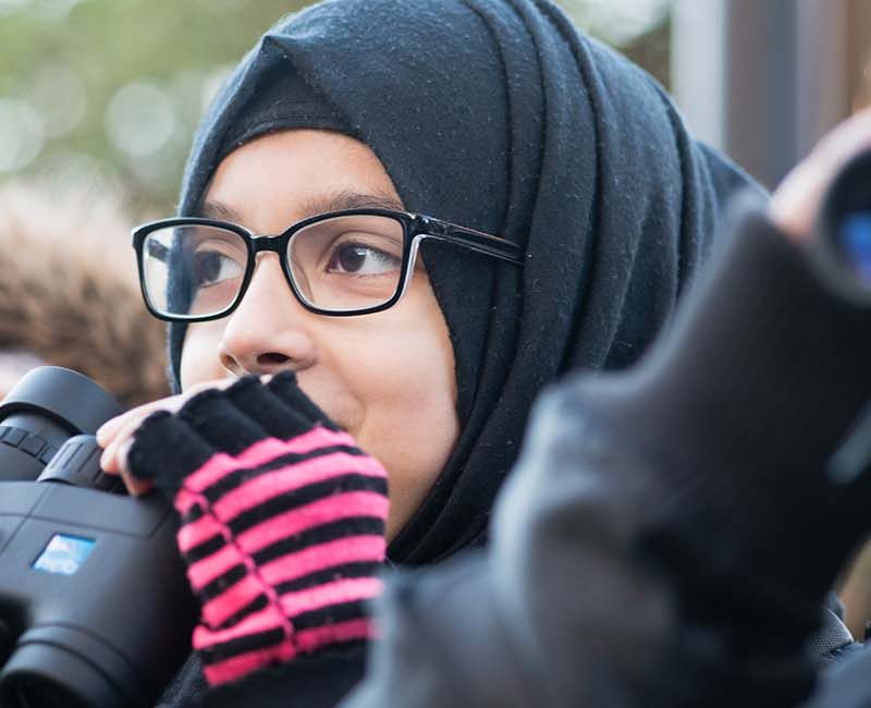 Young girls holding RSPB binoculars