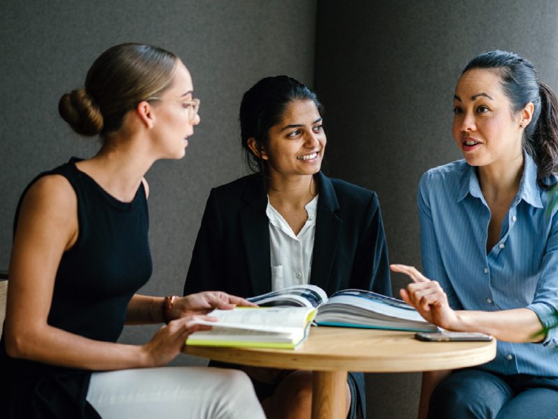 Three women sat at table chatting
