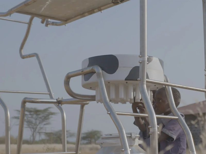 Two children looking at Solar Cow charging station