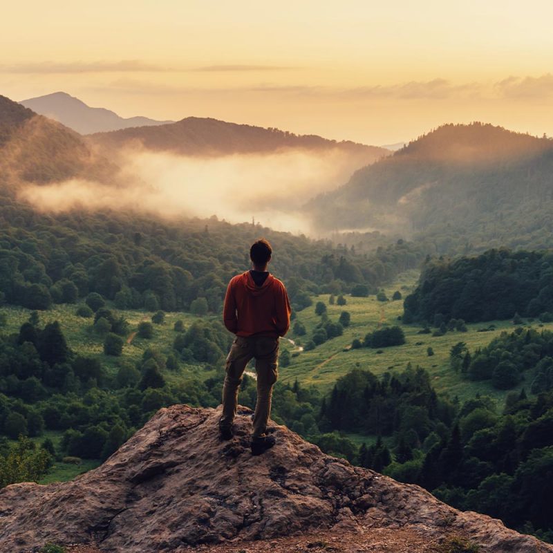Man standing on clifftop looking out