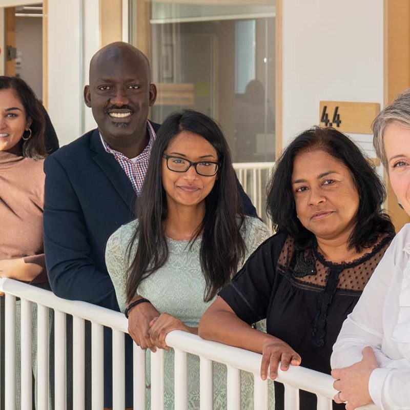Jenny and other staff hired by Oxford HR standing on balcony