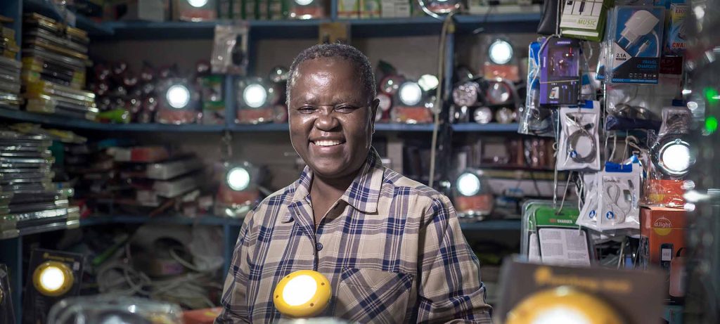 Kenyan man smiling surrounded by shining lights in shop