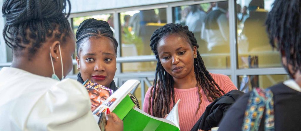 Group of women reading APHRC brochure at conference