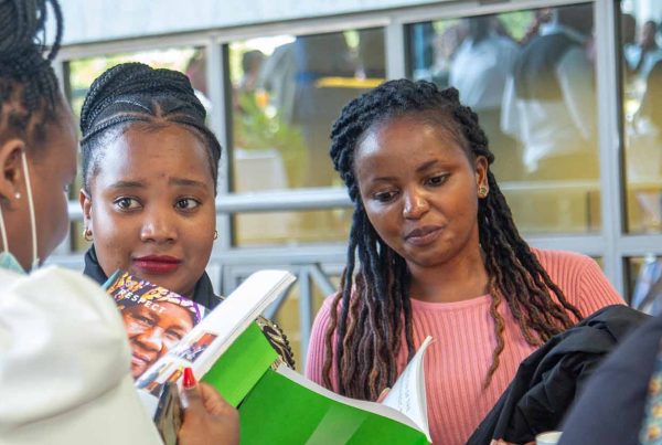 Group of women reading APHRC brochure at conference