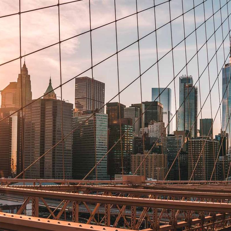 Sun setting over Manhattan skyline from Brooklyn bridge