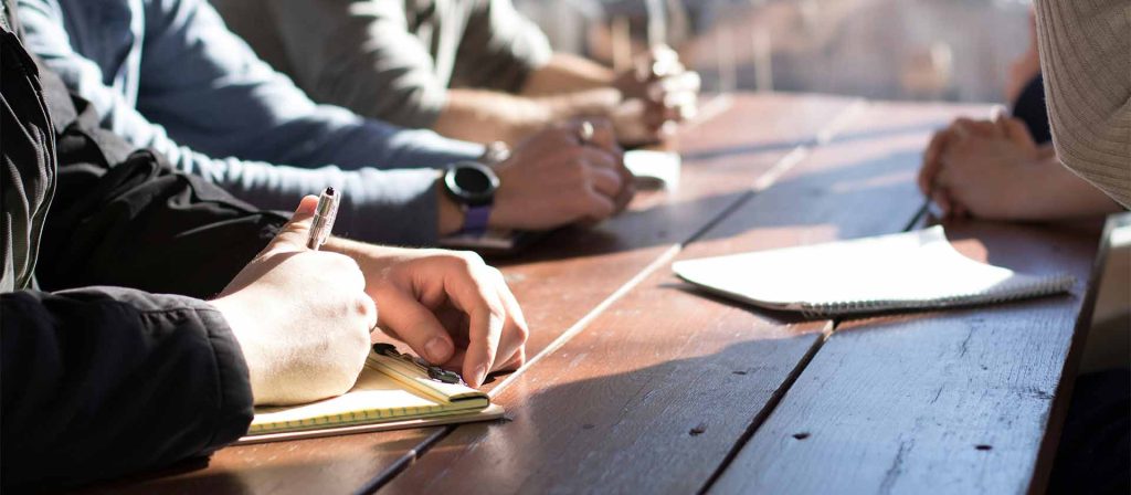 Group of people sitting around a desk planning