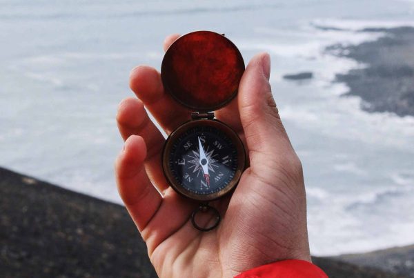 Man with a compass overlooking the sea
